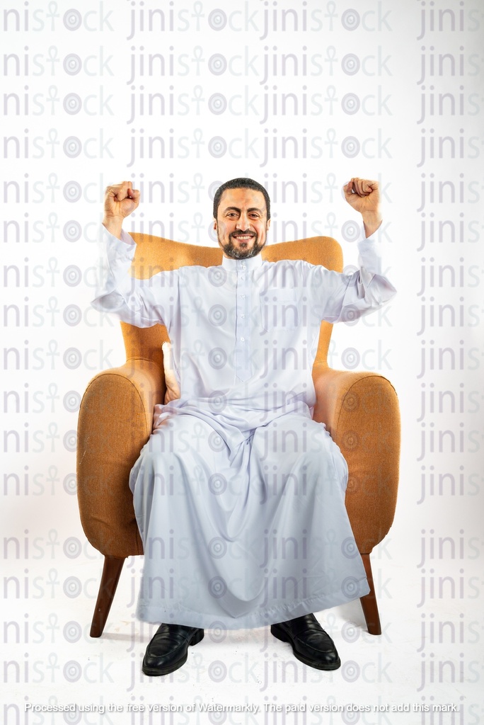 رجل سعودي خليجي سعيد يهتف وهو جالس على كرسي
