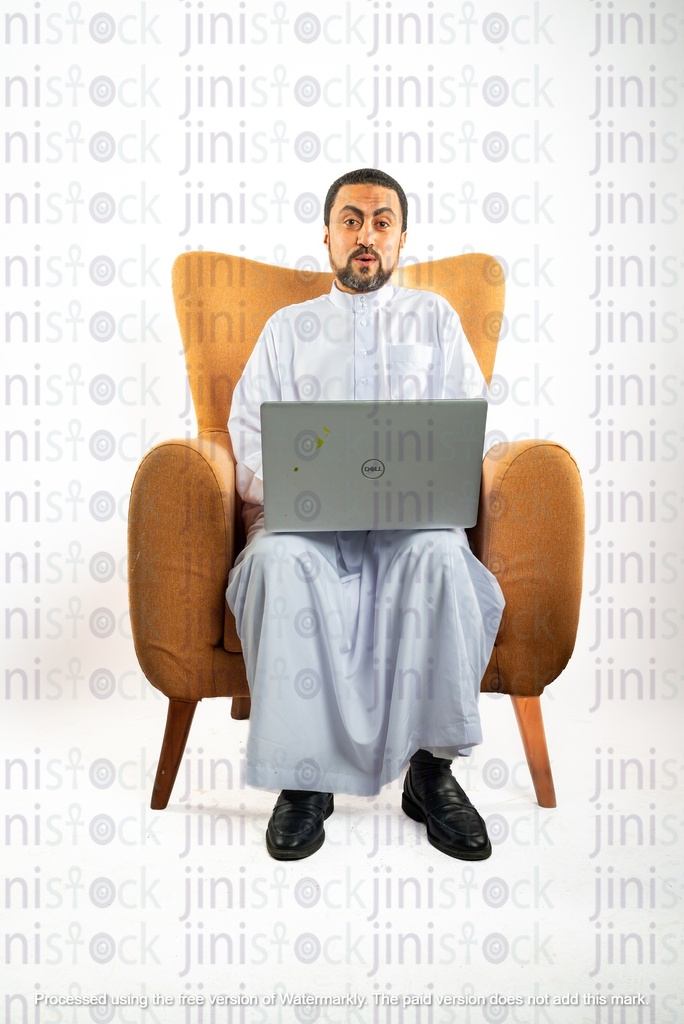 saudi khaliji man from gulf sitting on a chair working on his laptop and surprised