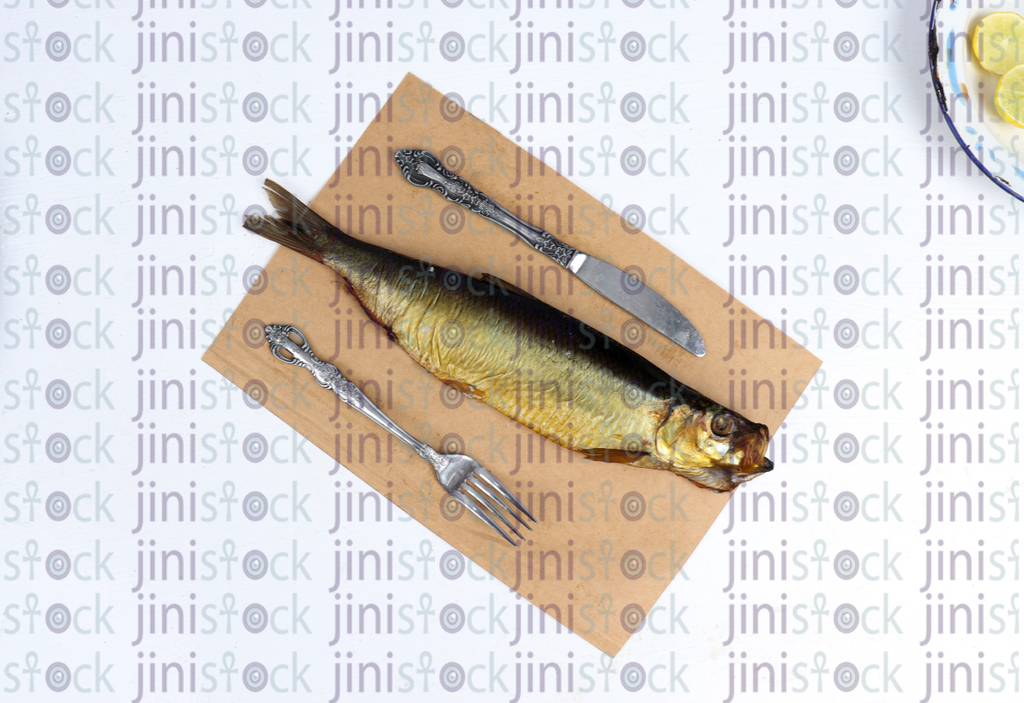 Renga fish next to fork and knif-stock image