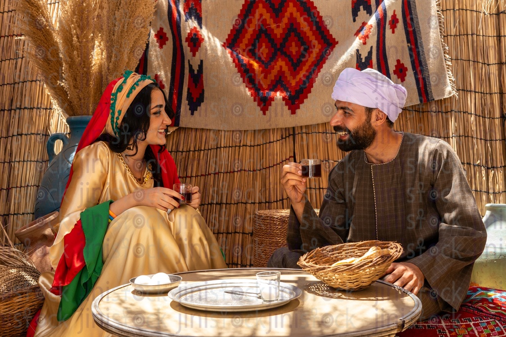 An Egyptian farmer happily drinks tea with his wife 