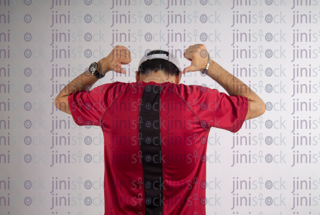 back of a man in a red T-shirt pointing to his back - stock image