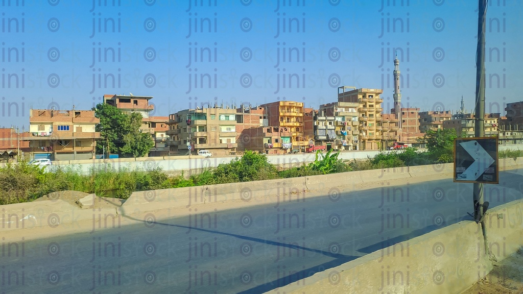 A road in the countryside with no cars or transportation, plants and rural buildings