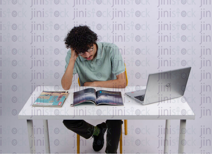 a young man reading in abook - stock image