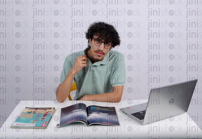 a young man with curly hair feeling hot while studying - stock image