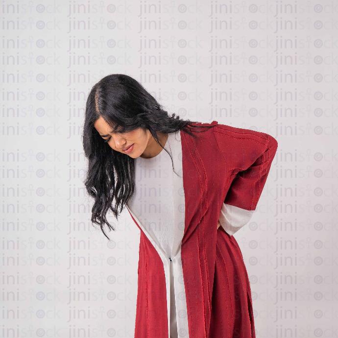khaliji woman with back pain isolated background - Stock image