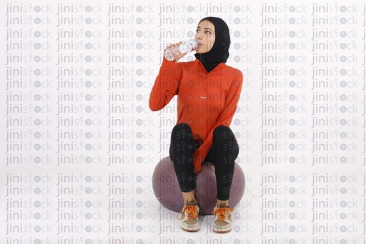 A veiled female model is working out with dumbbells wearing a hijab on isolated background stock image with high quality