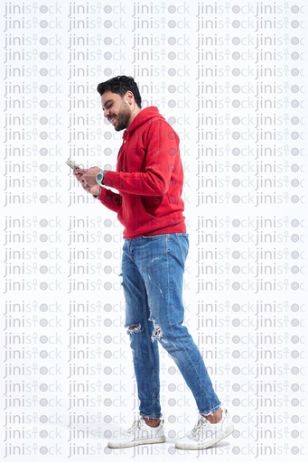 Young man walking while texting or looking in his mobile