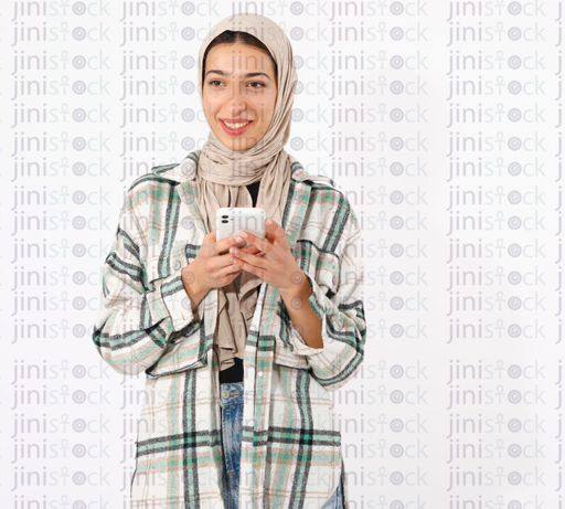 Smiling young hijabi girl holding cellular phone