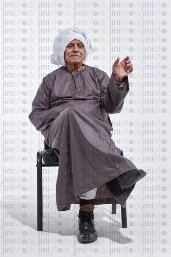 old man wearing a galabia and holding something in his hand