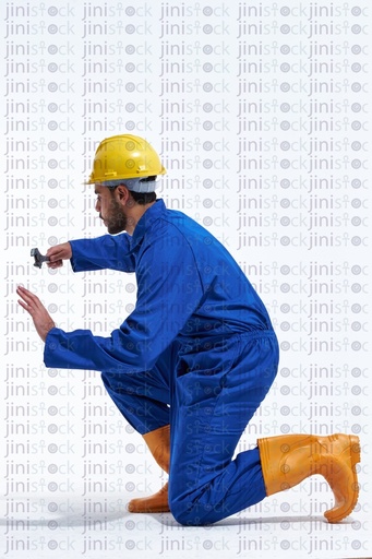 Young worker on his knees working side view