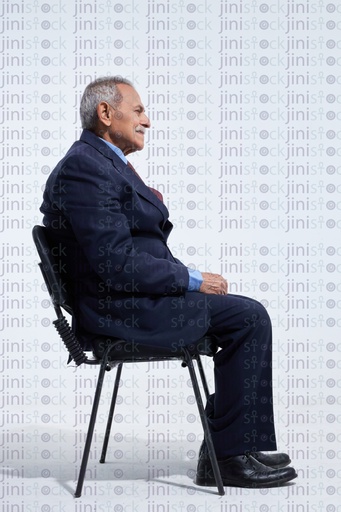 old man in a business suite sitting happy