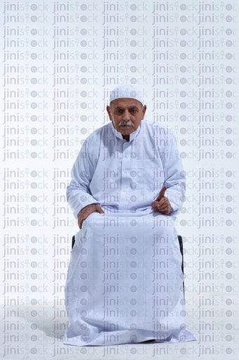 old man in praying or white galabia sitting on a chair