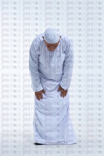 old man praying in a white galabia full length