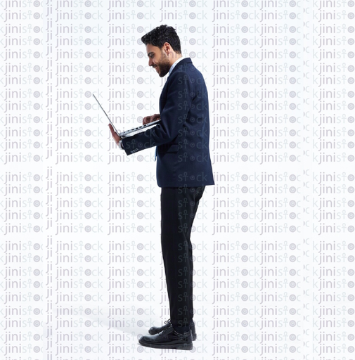 Man in a suite standing and working on a laptop side view