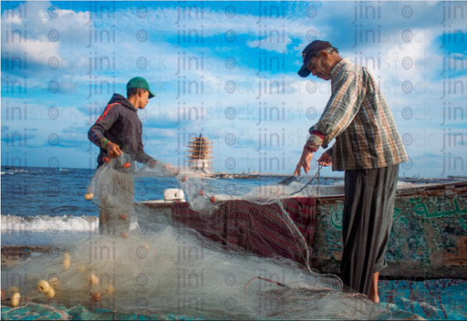 Two men fishing with nets from the sea - stock image