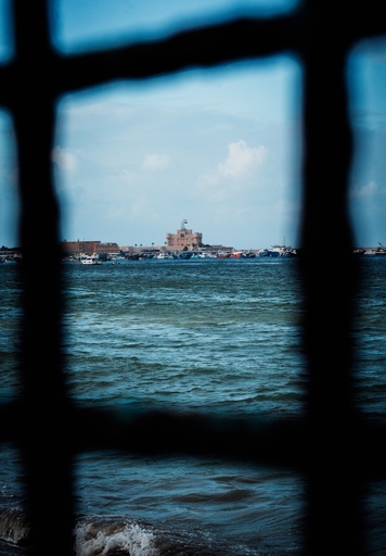 Qaitbay Citadel from behind iron bars - stock image