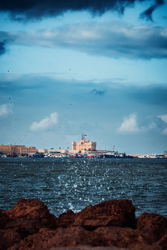 Qaitbay Citadel from behind the rocks - a remote photo - stock image