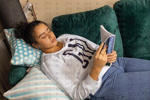 Woman laying on the couch reading