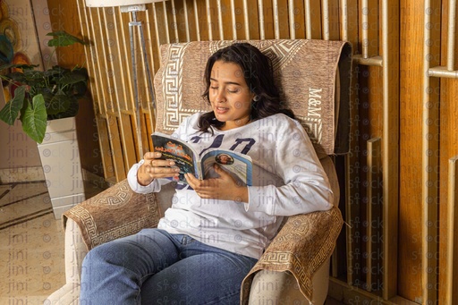 woman reading a book on achair