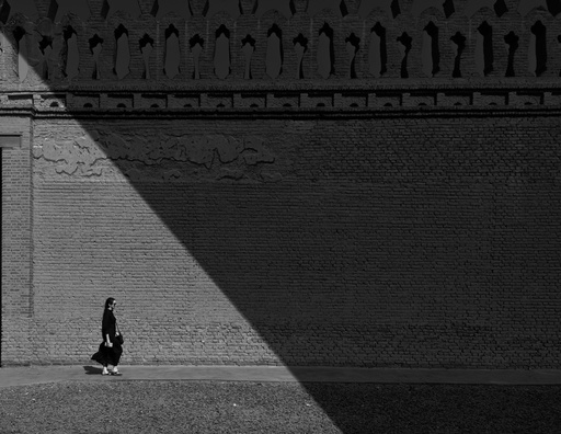 woman walking next to a wall