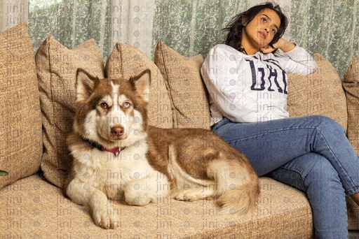 woman sitting down next to her dog at home