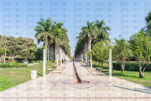 fountain at the end of a road with palm trees on its sides in the Azhar