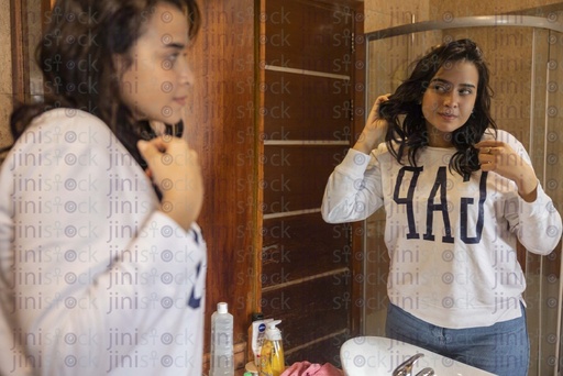 woman checking her hair in the mirror with good hair