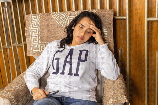 tired woman with a headache sitting on a chair