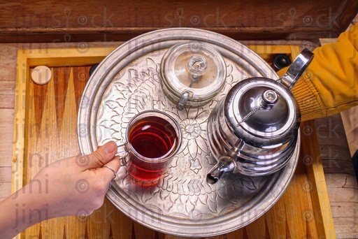 waiter handing tea to someone in an Egyptian coffee shop