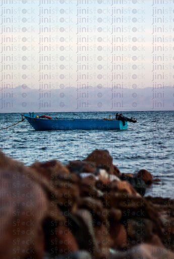 fishing boat in the sea through rocks