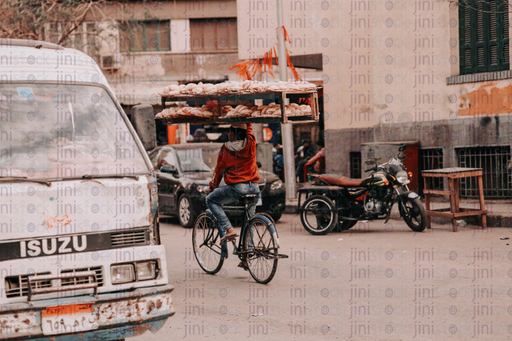 Man on the bike carring bread - stock image