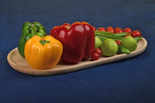 Colored pepper red, yellow, green, hot pepper, small tomatoes and lemon on a wooden plate. Food photography.