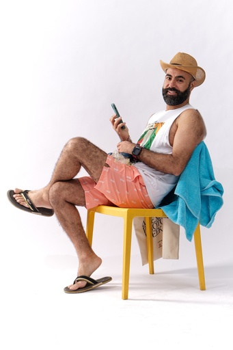 Man with a beard holding a phone in a summer cloths .