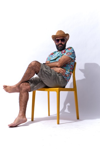man sitting with leg on leg in summer cloth.