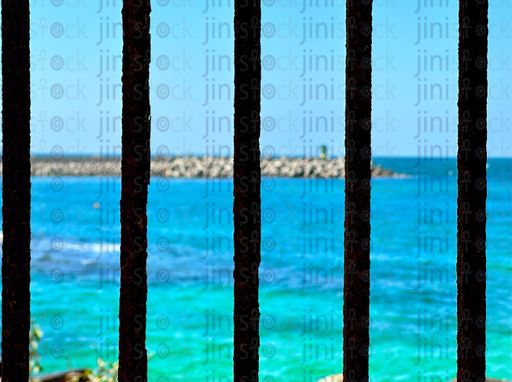 sea view through old rusty bars - stock image