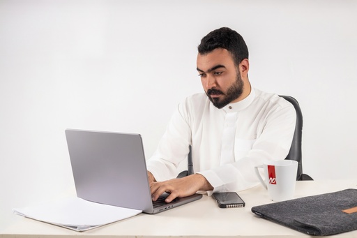 khaliji man stock image looking on laptop