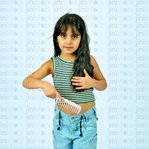 A child combs her hair with a comb