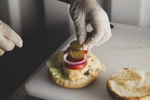 adding pickles to a burger