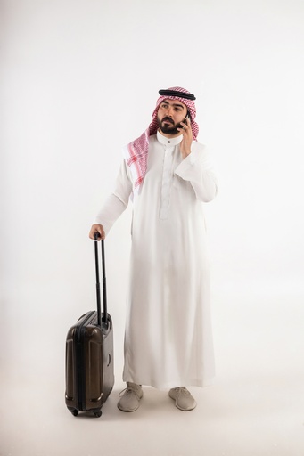 khaliji man with travel bag while taking in the phone