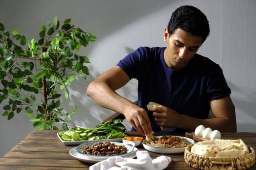 Young Egyptian man eating foul on breakfast