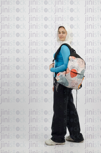 Hijab girl carrying a backpack - side photo - stock image