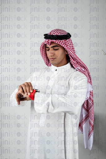 A young Gulf man checks the watch with interest