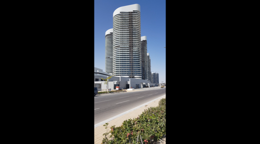 car traffic in front of high glass tower in alamein