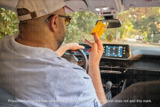 man in the driver seat holding a visa card