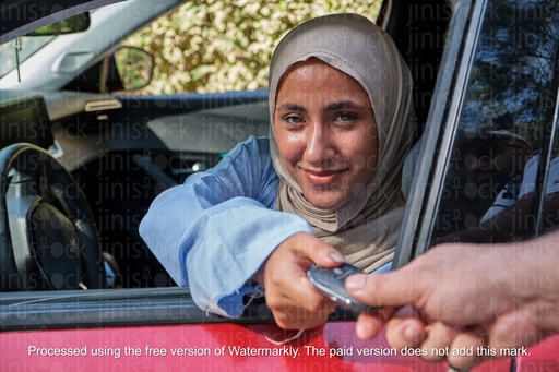 veiled woman receiving car keys