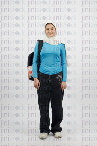 Veiled girl carrying a backpack - stock image