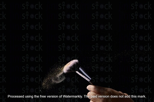 powder splash out of make up brush on a black back ground