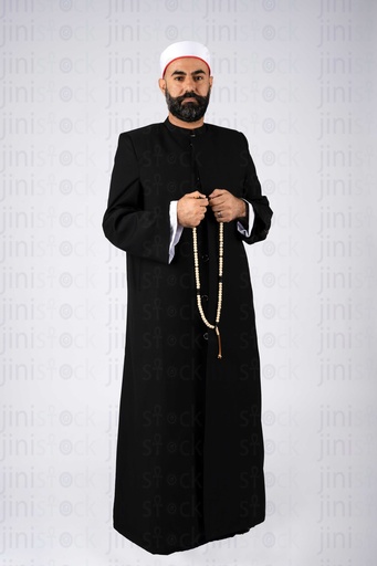 A sheikh is standing holding a rosary