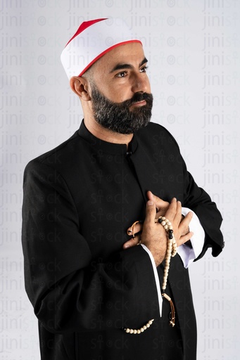 A sheikh holding a rosary with his hand on his chest