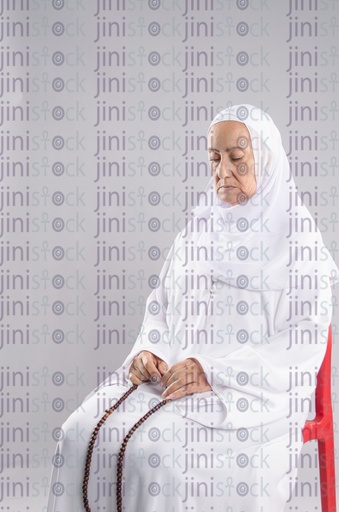 Old woman praying on a chair